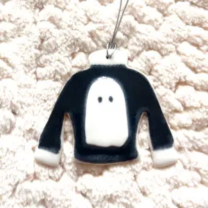 Porcelain Ghost Jumper pendant featuring a black sweater design with a white ghost on a textured white background.